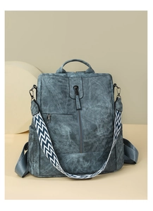 Détail du sac à dos bleu en PU avec sangle tissée géométrique et poche zippée