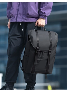 Detail of a large black waterproof outdoor backpack with quick-release buckles and straps