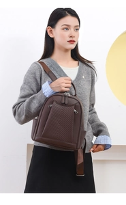 Detailed close-up of dark brown faux leather backpack featuring V-shaped stitching