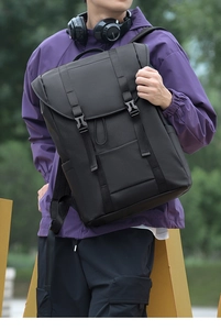 Detailed view of black waterproof outdoor backpack with dual buckles on a model