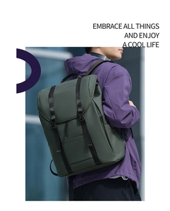 Outdoor model wearing dark green waterproof travel backpack with black adjustable straps