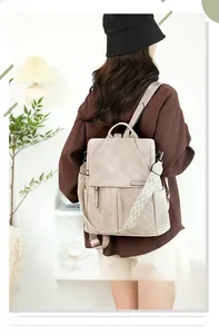 Dettaglio dello zaino antifurto beige con tracolla etnica intrecciata mostrato sul modello