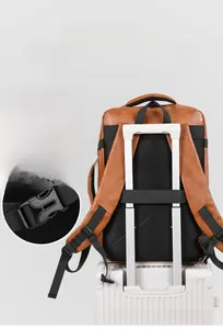 Detail of brown leather backpack showing breathable honeycomb mesh and luggage strap
