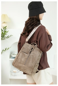Détail d'un sac à dos vintage en cuir PU marron avec bandoulière à motif géométrique