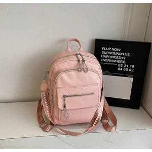 Detail view of pink PU leather backpack featuring ethnic woven straps and dual zippers