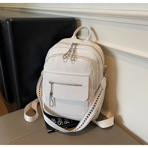 Detail of white PU leather backpack featuring woven geometric straps and dual zip pockets