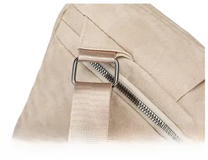 Dettaglio della fibbia di regolazione in metallo argentato su uno zaino beige