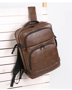 Detail view of deep brown vintage leather texture and multi-pocket business backpack design