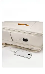 Detail of side view of white laptop backpack showing external USB port and charging cable