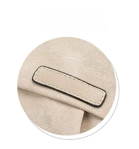 Dettaglio dello zaino in tela beige che mostra le cuciture sottili e la trama della toppa