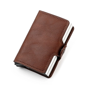 Detail of brown leather RFID card holder with automatic pop-up aluminum case and snap closure