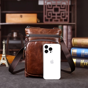 Dettaglio della borsa a tracolla vintage in pelle marrone con tasche e texture di qualità