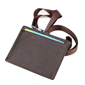 Porta acreditación de cuero marrón con cordón y clip metálico en fondo blanco