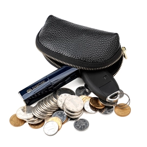 Detail view of large capacity black lychee grain leather pouch storing car keys and coins