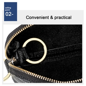 Macro view of black litchi grain leather key pouch with golden zipper and inner ring
