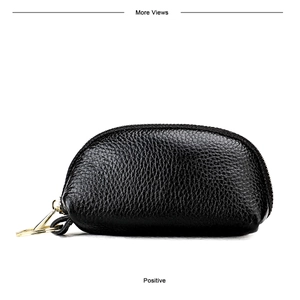 Detail of black lychee grain leather mini pouch with gold zipper and keychain ring