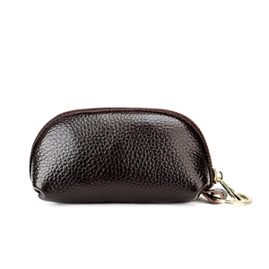 Detail of dark brown leather key pouch with lychee texture and gold key ring