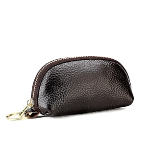 Macro view of dark brown litchi grain leather pouch with golden zipper and key ring