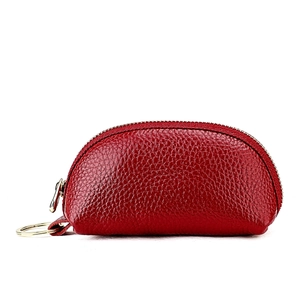 Macro detail of red lychee grain leather coin purse with golden zipper and key ring
