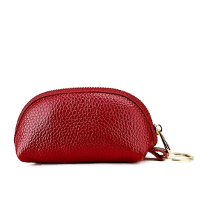 Macro detail of red lychee grain leather mini pouch with golden zipper and keyring