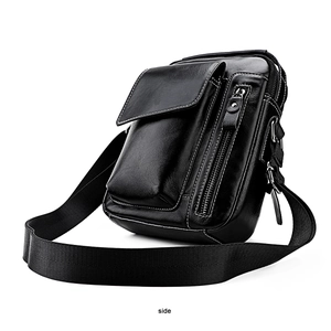 Detailed side view of black leather crossbody bag with contrast stitching and silver zippers