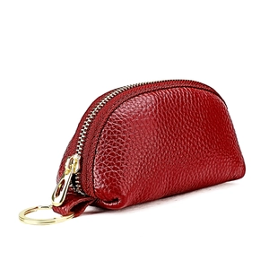 Close-up of red pebbled leather coin purse with golden zipper and metal keyring