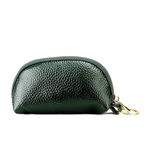 Detail of dark green pebble grain leather car key pouch with gold metal keyring