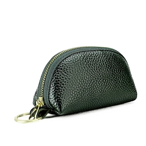 Detail of dark green pebble leather car key pouch with gold zipper and keychain