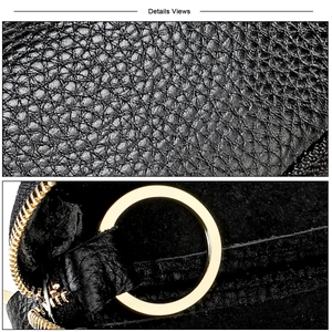 Macro view of black litchi grain leather texture and gold metal zipper hardware details
