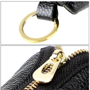 Macro detail of genuine pebble grain leather texture and premium gold metal zipper hardware