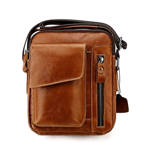 Detailed view of brown leather crossbody bag with multiple zip pockets and adjustable strap