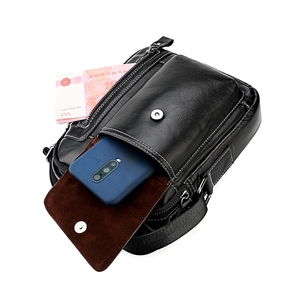 Men's black leather crossbody bag with white stitching and magnetic flap closure