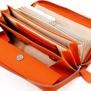Macro view of orange pebbled leather wallet featuring multi-layer accordion card slots