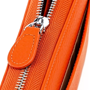 Detailed macro shot of orange lychee grain leather wallet with premium silver zipper