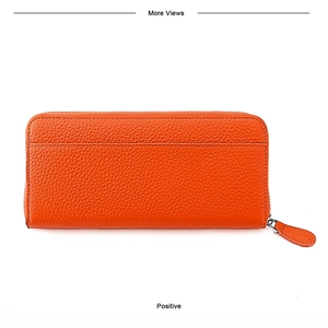 Detail of orange pebbled leather long wallet featuring back pocket and zipper puller