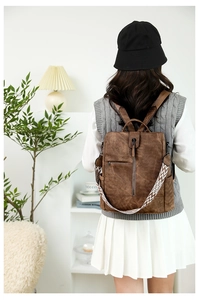Sac à dos en similicuir marron avec une bandoulière tissée géométrique noire et blanche