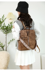 Détail du sac à dos en similicuir marron foncé avec bandoulière brodée bohème