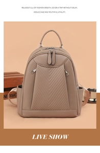 Detail of taupe lychee-grain leather backpack featuring V-shaped stitching and dual zippers