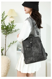 Détail d'un sac à dos gris foncé mat avec une large bandoulière à motifs géométriques