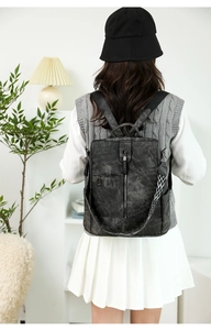 Détail d'un sac à dos vintage noir avec bandoulière tissée géométrique sur un modèle