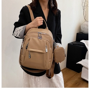 Stylish khaki leather backpack for women shown with matching small coin pouch accessory