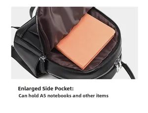 Detail view of the black leather backpack's large side pocket holding an A5 notebook
