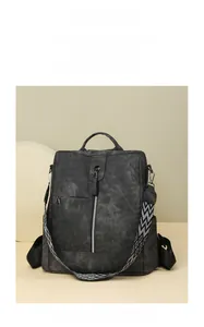 Détail d'un sac à dos vintage noir avec zip métallique et bandoulière tissée géométrique