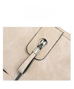 Détail d'une fermeture éclair en métal argenté sur un sac à dos en toile beige pour femme