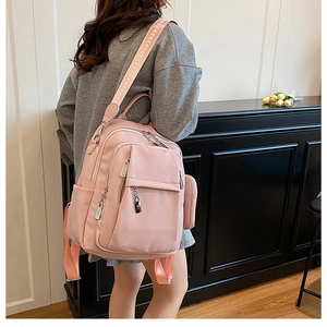 Detail of pink PU leather backpack with lychee texture and jacquard woven strap