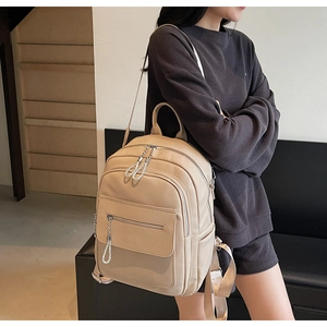 Detail view of beige faux leather backpack with lychee texture and diamond zipper pulls