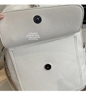 Detail eines weißen Lederrucksacks mit versteckter Magnetschnalle und Metallbeschlägen
