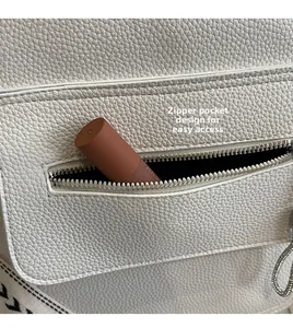 Detail eines weißen Lederrucksacks mit praktischer Reißverschlusstasche für Lipgloss