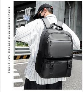 Close-up of black multi-compartment travel backpack with buckles in urban street setting