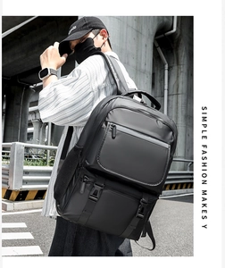 Outdoor shot of a black large capacity travel backpack with ergonomic shoulder straps